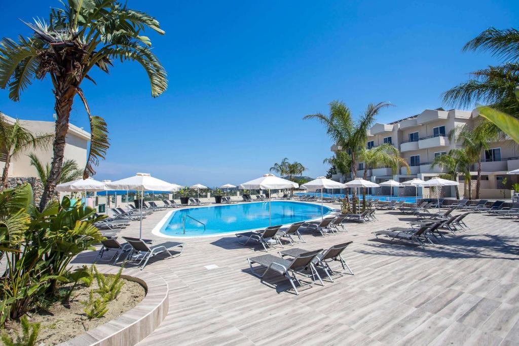 法里拉基威尼斯度假酒店的度假村的游泳池配有椅子和遮阳伞