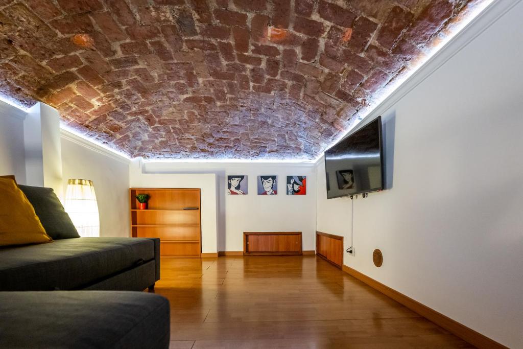 都灵CasaCasalis - Immersi nella Torino Liberty的一间设有砖砌天花板和沙发的客厅