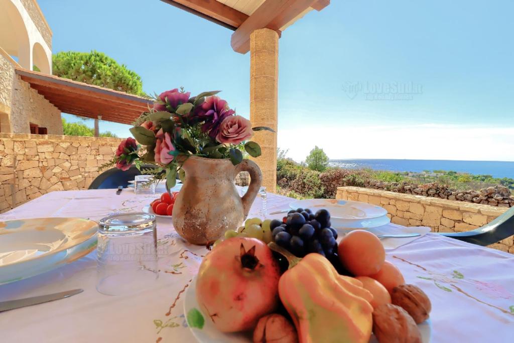 帕图Case Vacanze San Gregorio的一张桌子,上面有一盘水果和花瓶