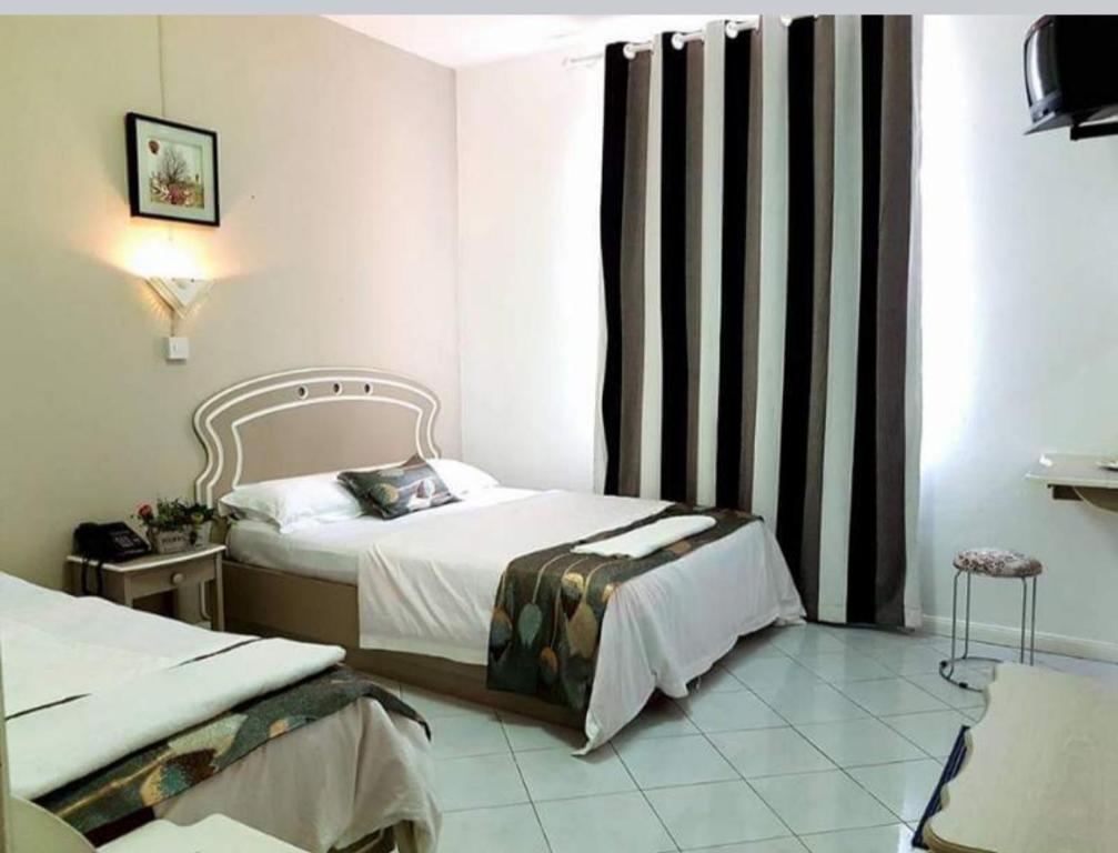 Roches BrunesEuro Vacances Guest House的酒店客房设有两张床和窗户。