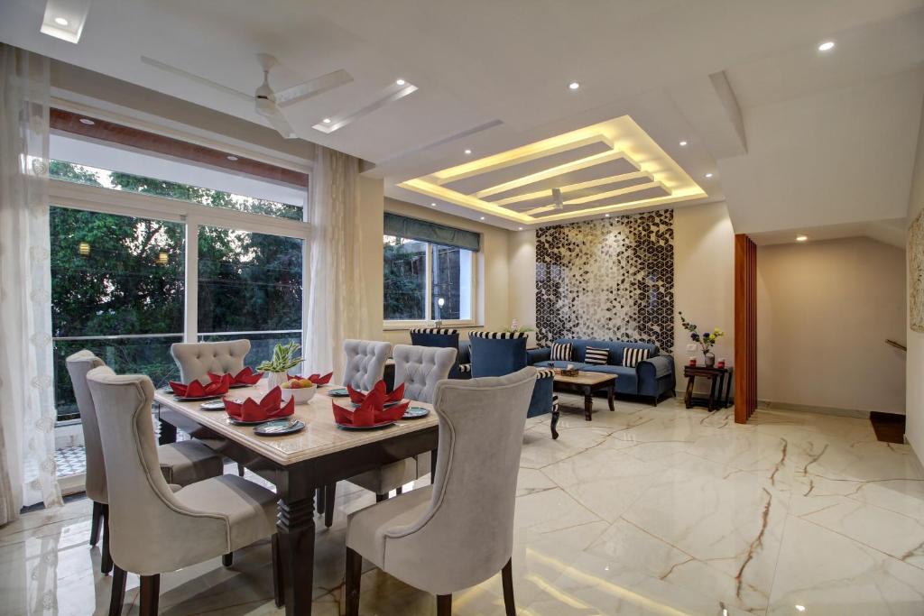 巴加Antalya Villa - 5BHK with Private Pool, Baga的用餐室以及带桌椅的起居室。
