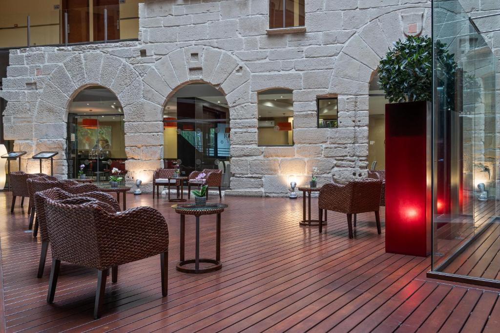 洛格罗尼奥F&G洛格罗尼奥酒店的大堂设有桌椅和石墙