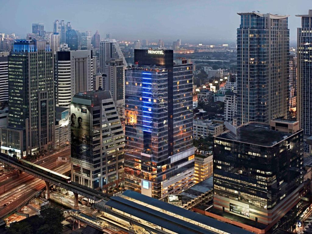 曼谷Novotel Bangkok Ploenchit Sukhumvit的享有夜间城市景观和建筑