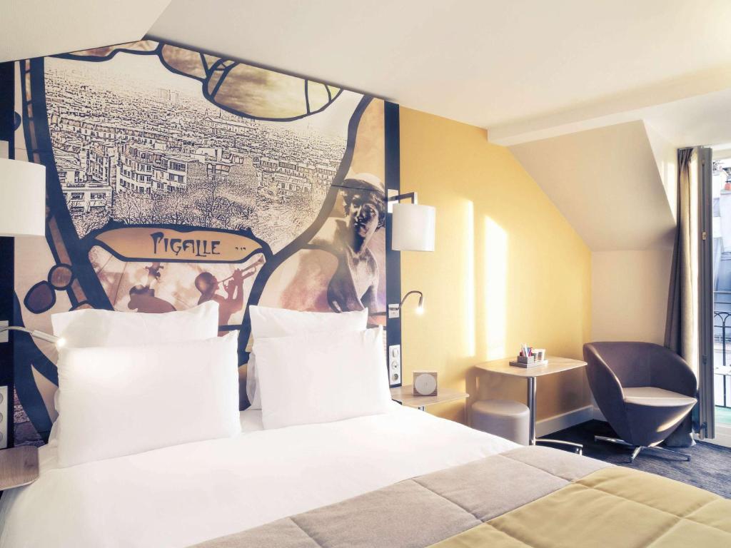 巴黎巴黎皮加勒圣心大教堂美居酒店的酒店客房的墙上设有一张带四柱床的床铺。