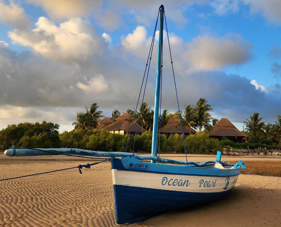 维兰库卢什Ocean Pearl Beach Lodge的一艘蓝白的船坐在海滩上