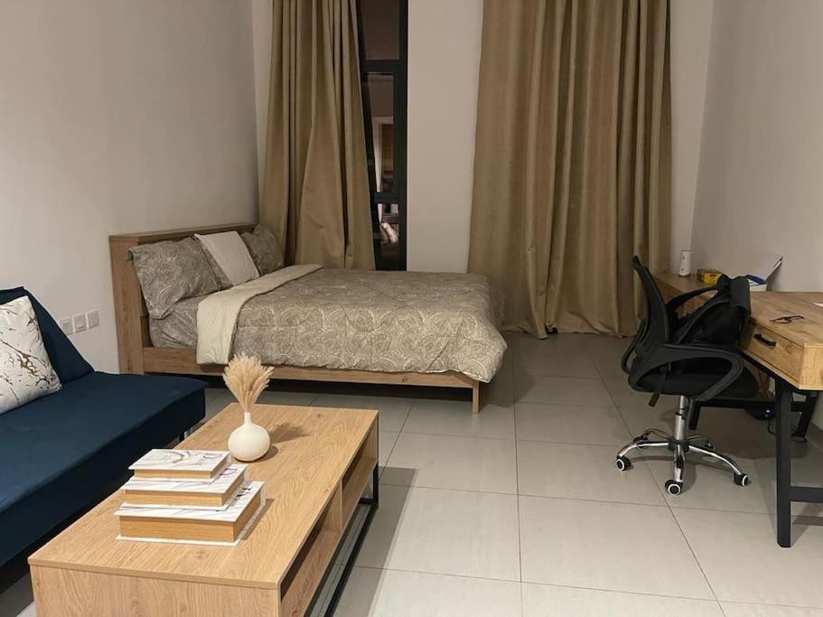 沙迦luxury 1 BR studio in Sharjah的客厅配有一张床、一张书桌和一张书桌