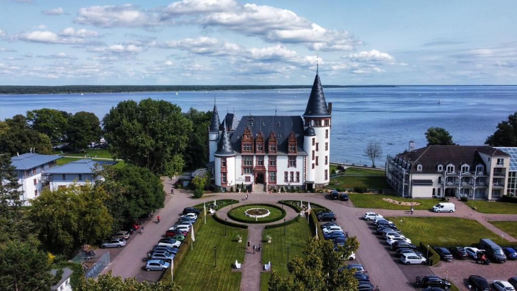 克林克Seehotel Schloss Klink的城堡的空中景观,停车场有车辆停放