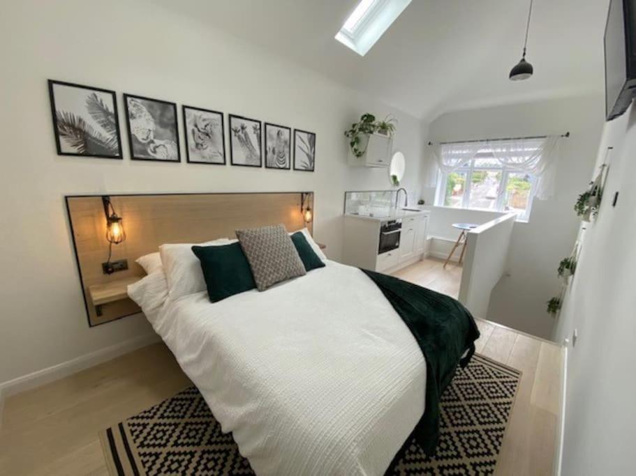 SaltfordThe Annex, Bath Road, Saltford的卧室配有一张带黑色枕头的大型白色床。