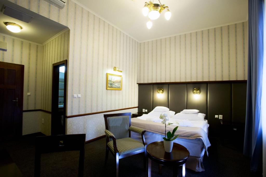 莱维采金鹰酒店的酒店客房带一张床、一张桌子和椅子