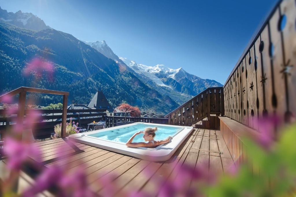 夏蒙尼-勃朗峰瑞士公园温泉酒店的躺在山间甲板上的一个游泳池里的女人