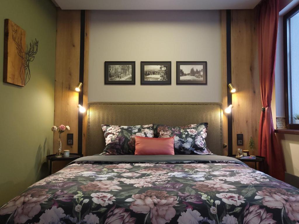 波罗维茨Pinewood ANG luxurious apartment A32的一间卧室配有一张带花卉床罩的大床