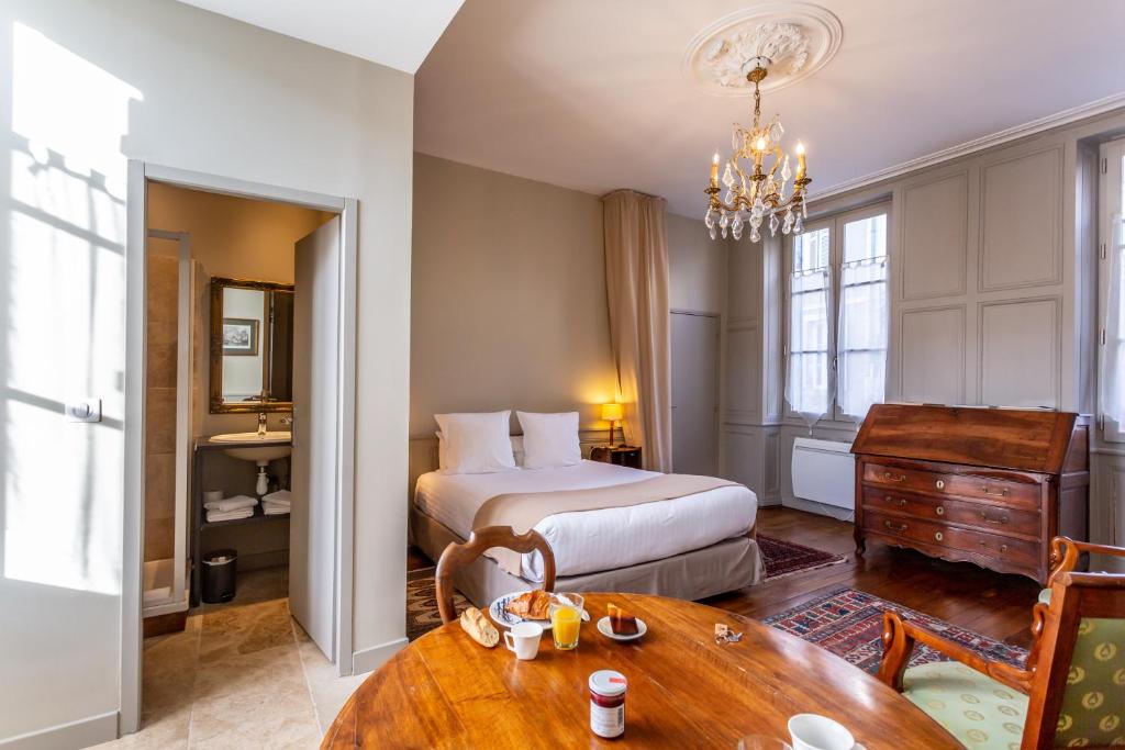 布尔日La Maison d'Aristide - Les Univers de Panette的酒店客房配有一张床铺和一张桌子。