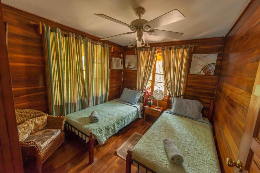 博卡斯德尔托罗Hotel Tierra Verde的客厅配有两张床和吊扇