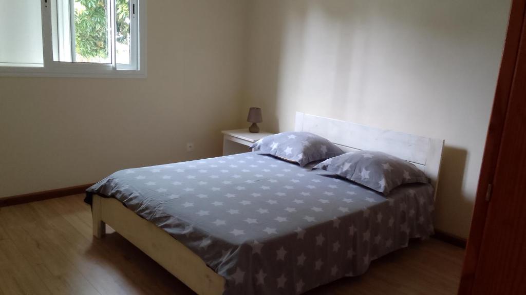 勒唐蓬Maison reposante的卧室配有带枕头的床铺和窗户。