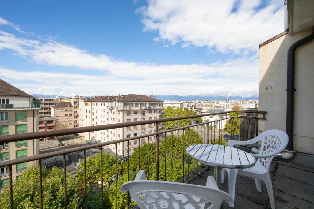 日内瓦Primadom Aparthotel的设有一个配有桌椅并享有美景的阳台。