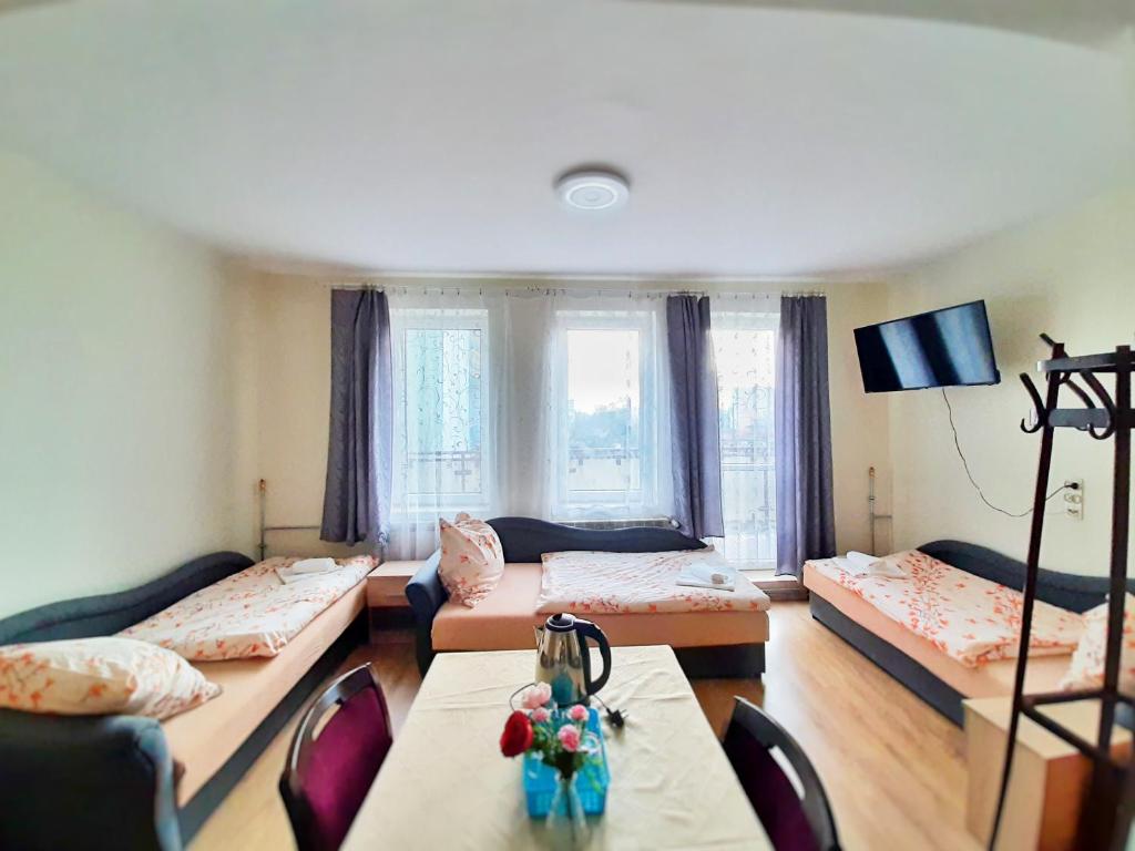 拉多姆斯科HOTEL RADOMSKO的客厅配有三张床和一张桌子
