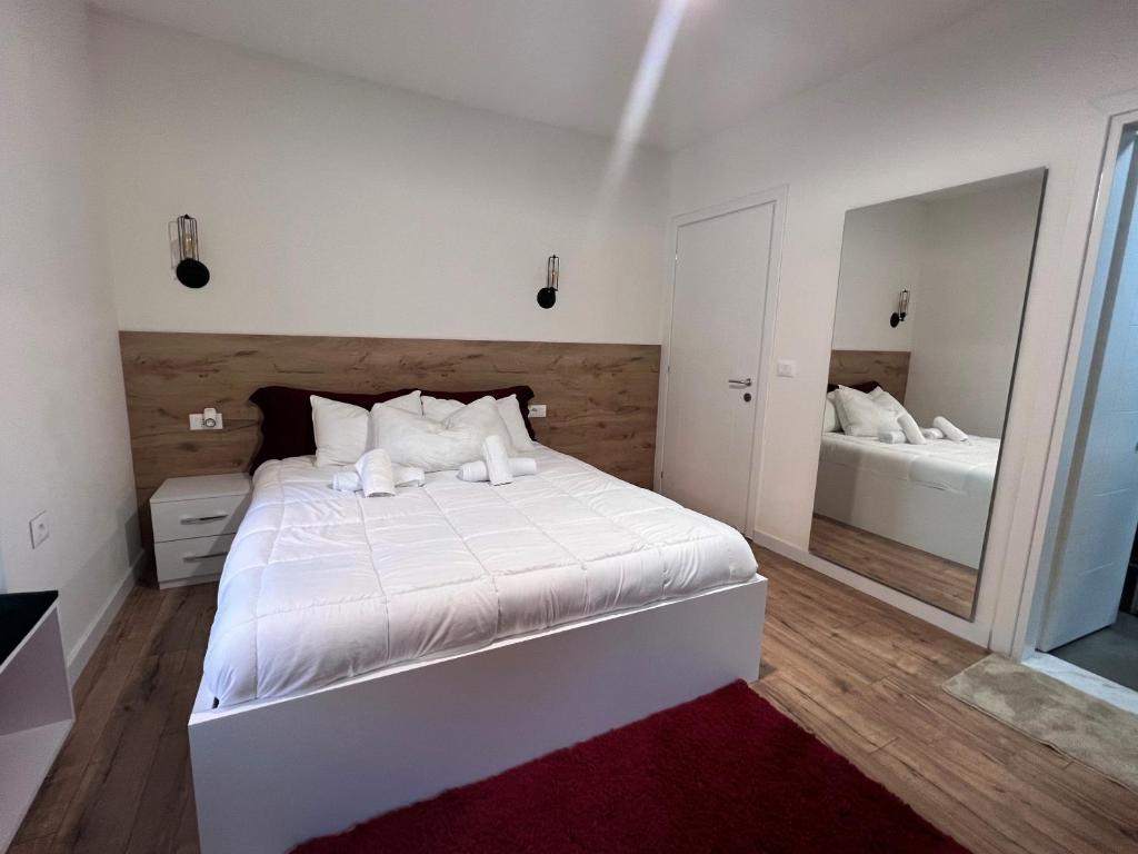 地拉那Grand Park & Bllok Area Rooms的卧室配有白色的床和镜子