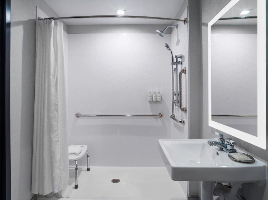 尼亚加拉瀑布voco - The Cadence, an IHG Hotel的白色的浴室设有水槽和淋浴。