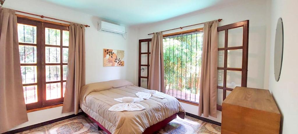 伊瓜苏港Orquídeas De La Selva的一间卧室设有一张床和两个窗户。