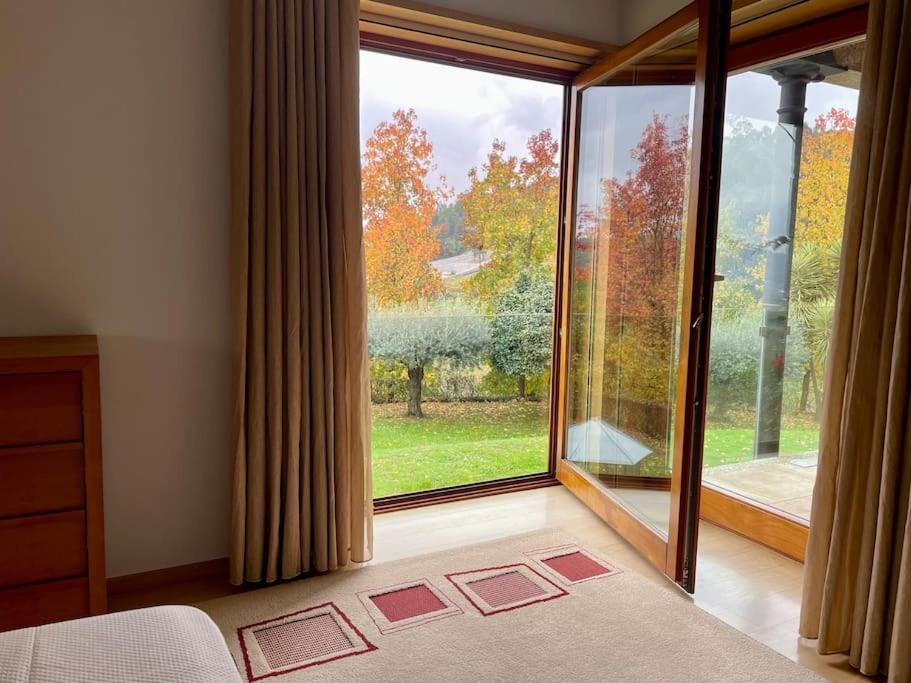 吉马良斯Quinta Picouto de Cima的一间卧室设有美景大窗户