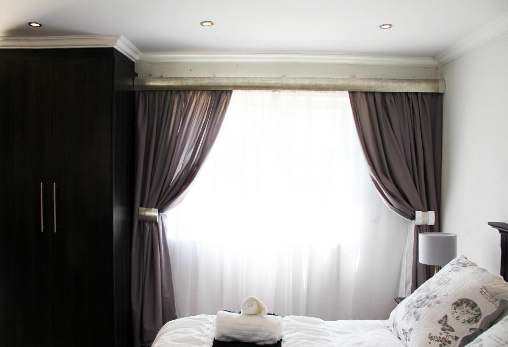 伊登维尔La Coscello Guest House的一间卧室设有一张床和一个大窗户