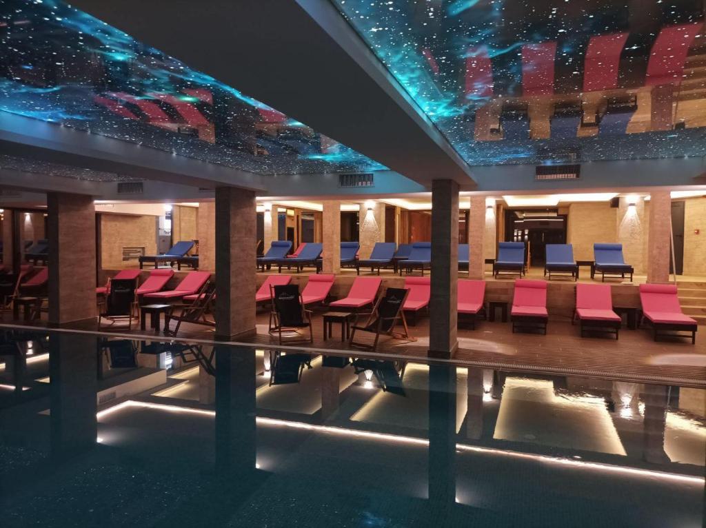 科帕奥尼克L&N Apartmani Kopaonik-Milmari Resort的一个带椅子的大堂和一个游泳池