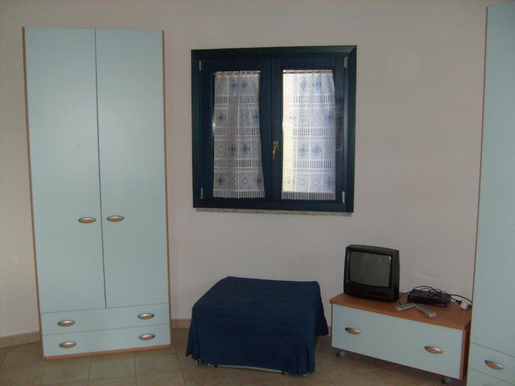瓦雷多利亚Valledoria 2 Apartments的一间卧室设有一张床和一个窗口