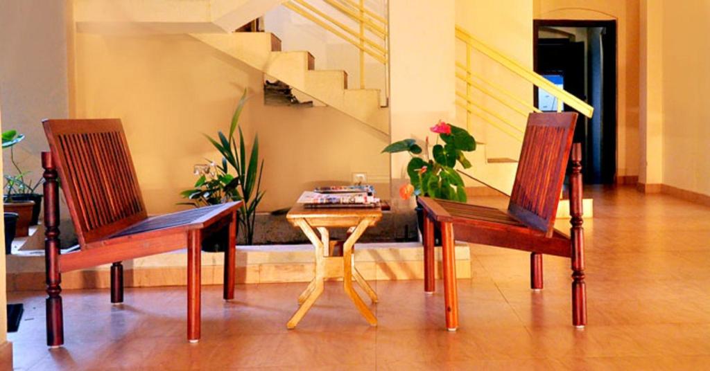德里久尔Wariyam Heritage的客厅配有两把椅子和一张桌子