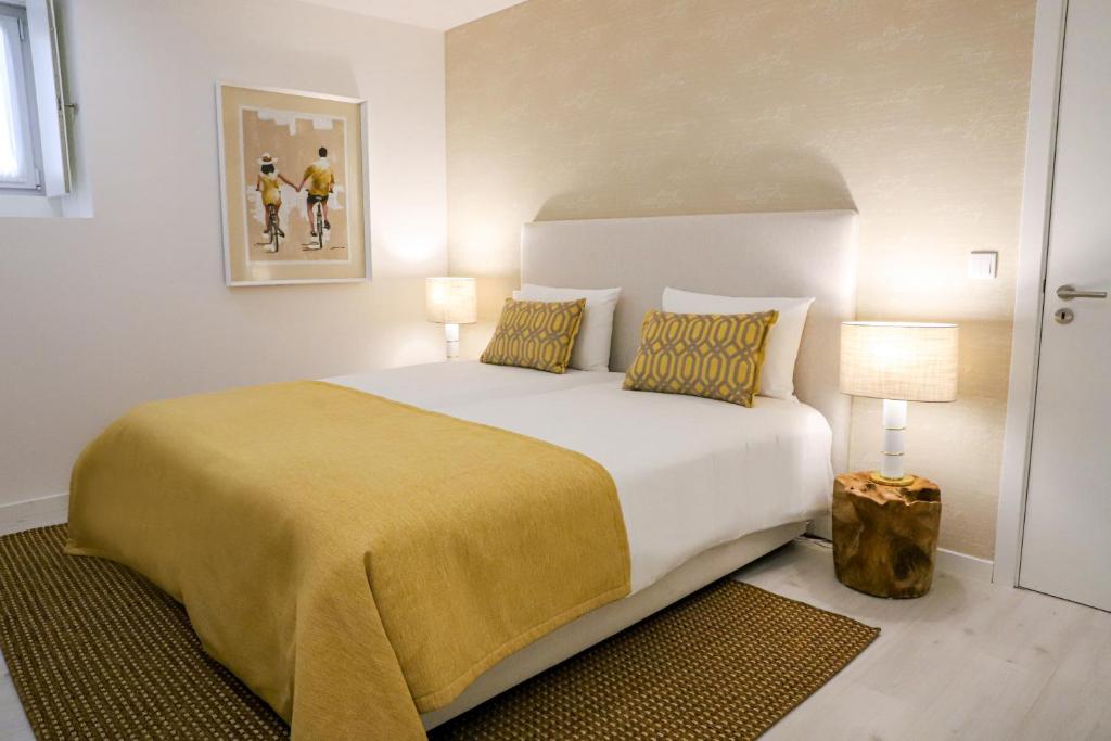 莱里亚Canto dos Poetas的一间卧室配有一张带黄色毯子的大床