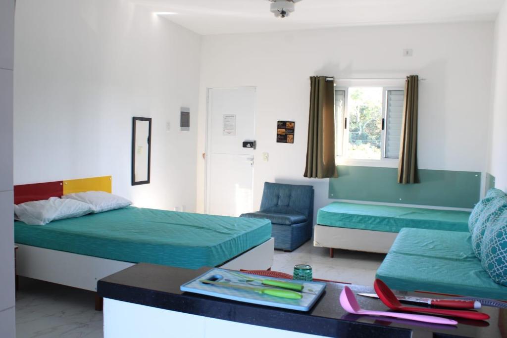 伯迪亚哥Kitnet Maitinga的客厅配有两张床和一张桌子