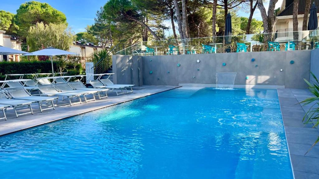 利尼亚诺萨比亚多罗总统酒店的一个带椅子的游泳池和一个游泳池