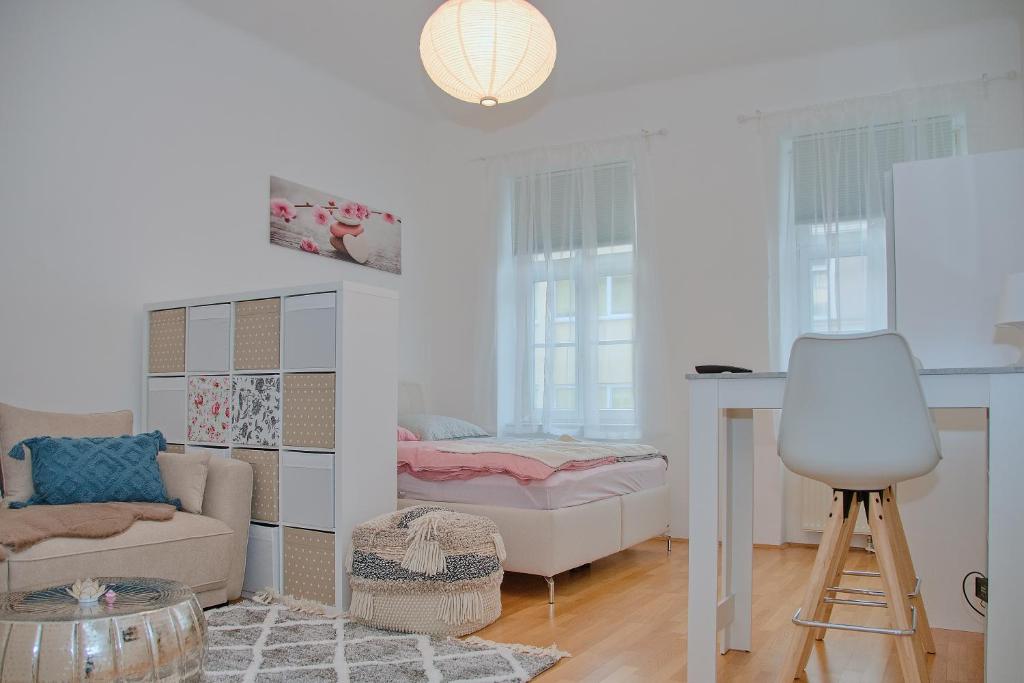 维也纳White Lotus Apartment的客厅配有床和桌子