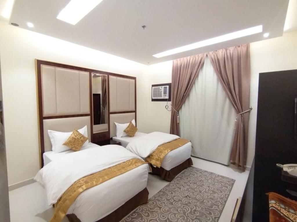Al MikhlafAl Shark Park Serviced Apartment的酒店客房设有两张床和窗户。