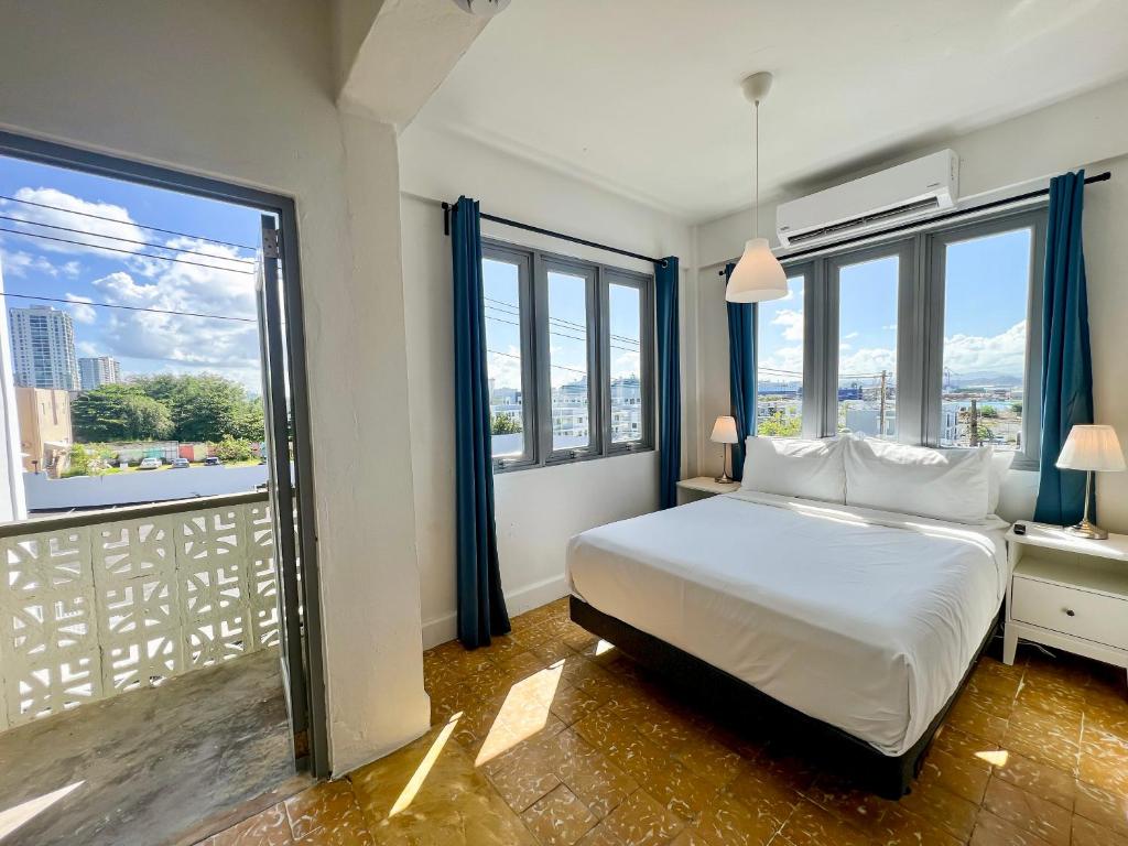 圣胡安Urbana Hotel的一间卧室设有一张床和大窗户
