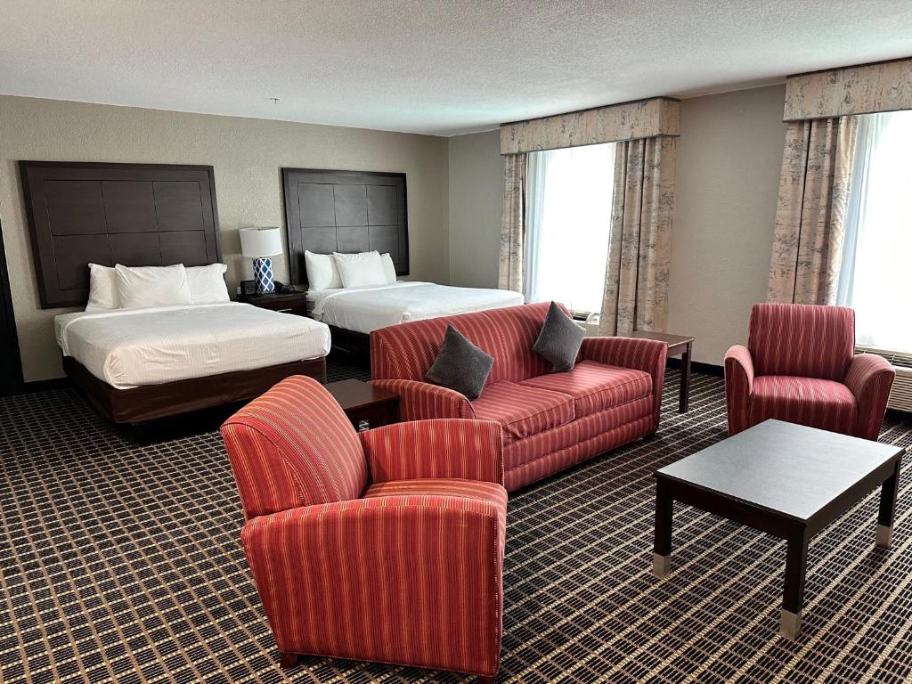 达拉斯Alexis Hotel & Banquets Dallas Park Central Galleria的酒店客房配有一张床、一张沙发和椅子。