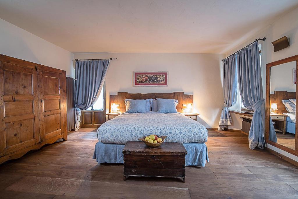 奥斯塔多莫斯蒂卡奥斯塔酒店的一间卧室配有一张带蓝色窗帘的大床