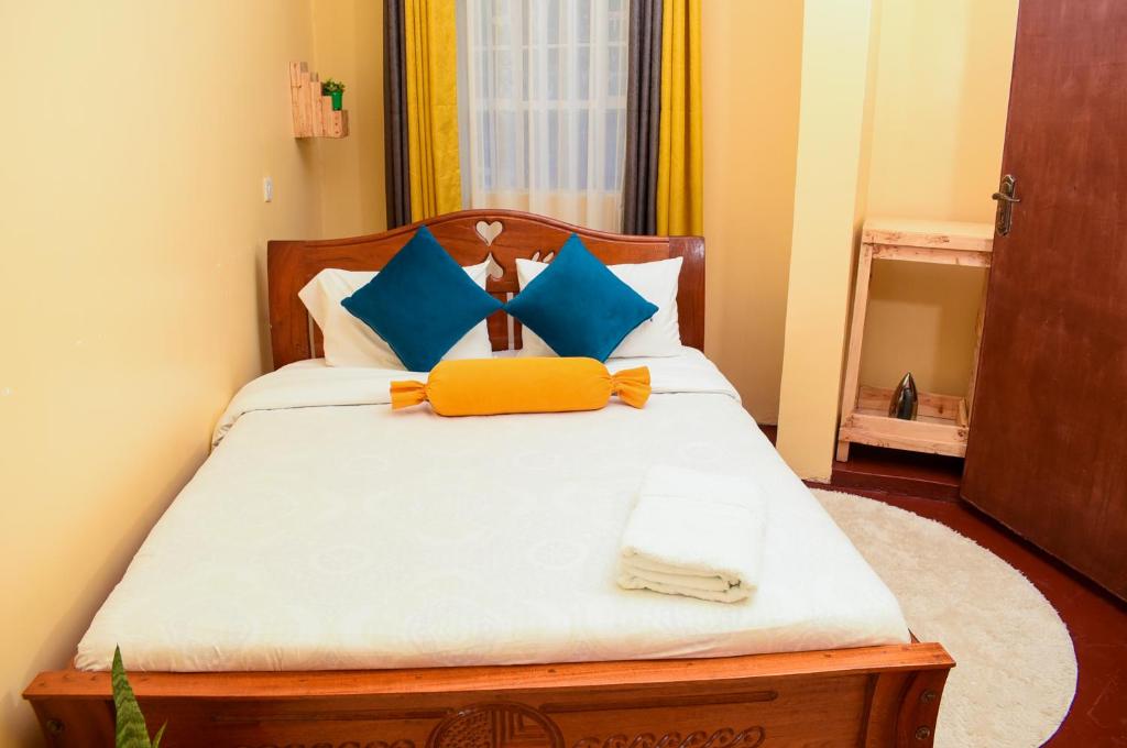 奈瓦沙Naivasha Southlake apartments的一间卧室配有蓝色和黄色枕头的床