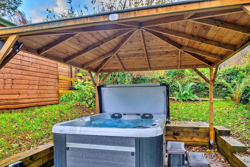 多尔威泽兰Finest Retreats - Harp House的木制凉棚下的热水浴池