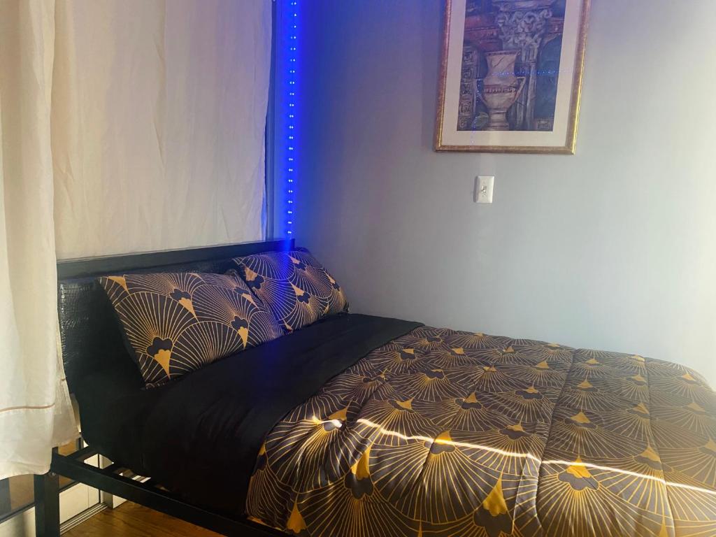 CoronaDouble-Mirrored Glass Room in Queens的一间卧室配有一张带黑色棉被的床