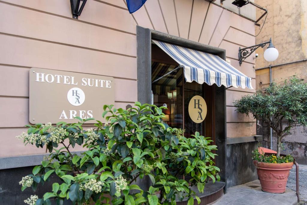 那不勒斯Hotel Suite Ares的大楼一侧带有标志的酒店入口