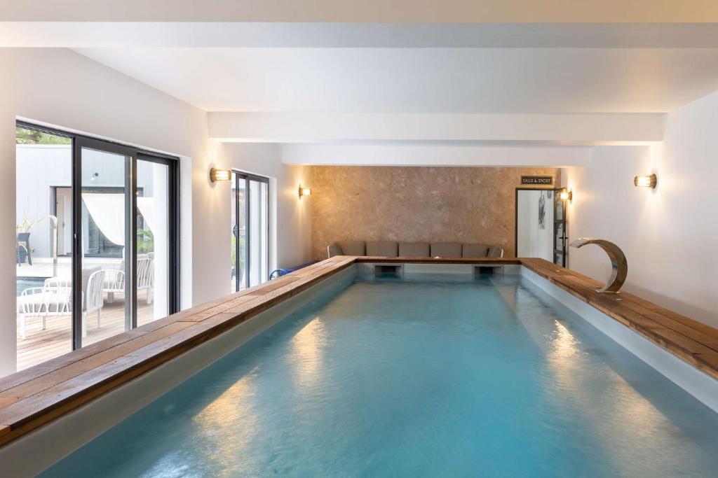 卡尔维Best Western Hotel Casa Bianca的一座带大窗户的房屋内的游泳池