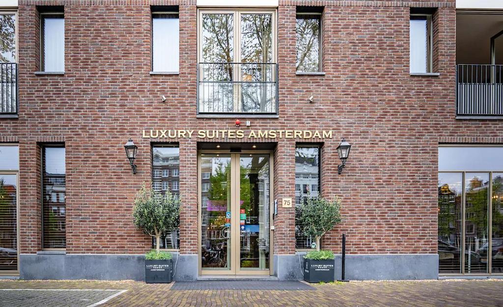 阿姆斯特丹Luxury Suites Amsterdam的一座砖砌建筑,上面标有阅读图书馆套房大使的标志