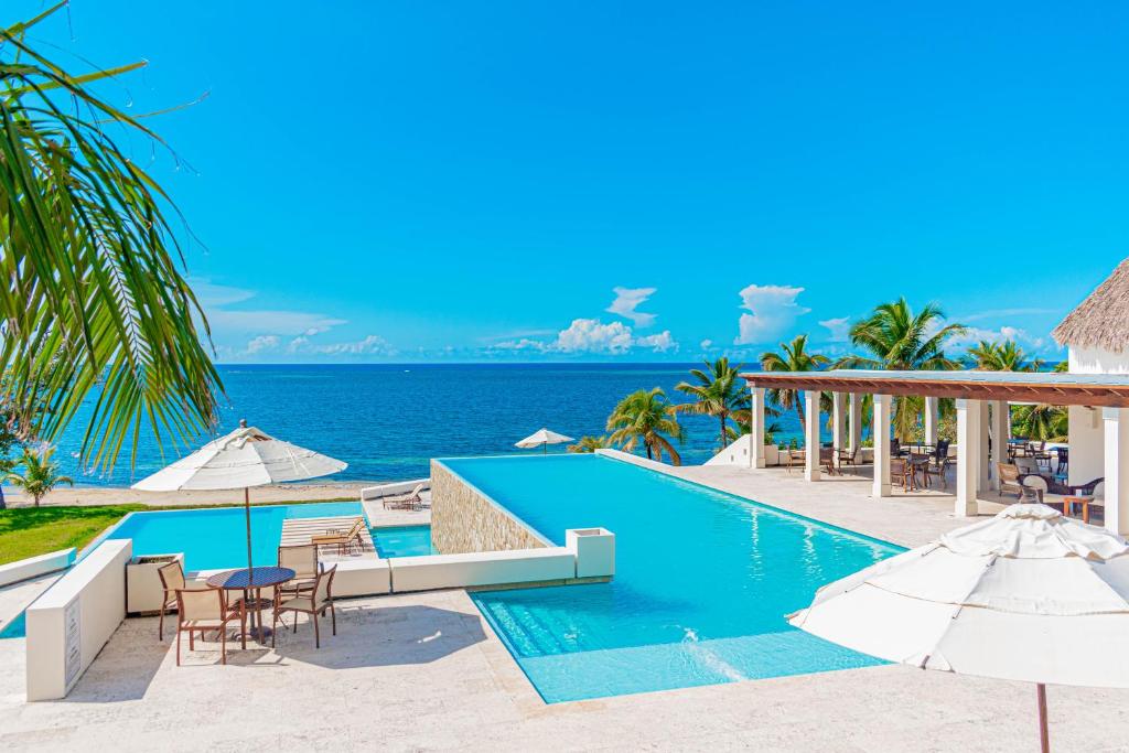 First BightLas Verandas Hotel & Villas的海滩上的游泳池配有椅子和遮阳伞