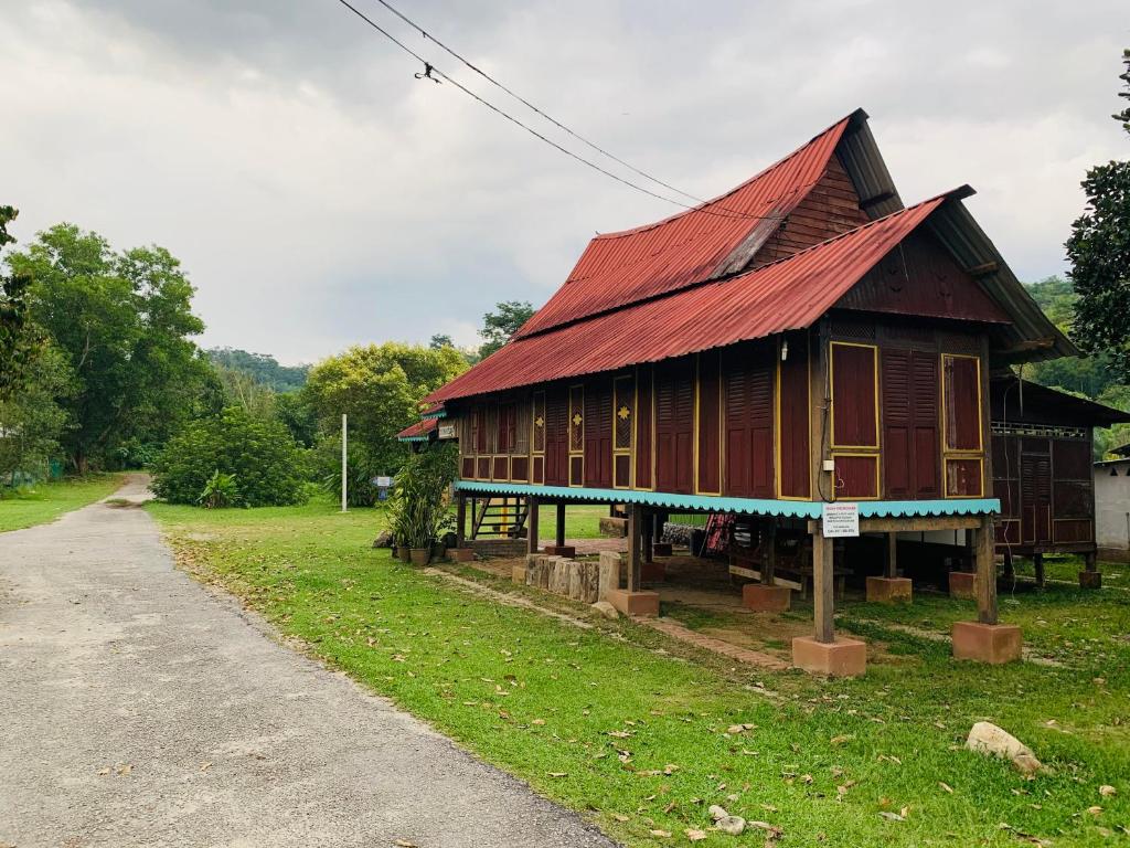 Kampong Ulu KalongPort Mancing Fishing Village的一座带红色屋顶的小木房子