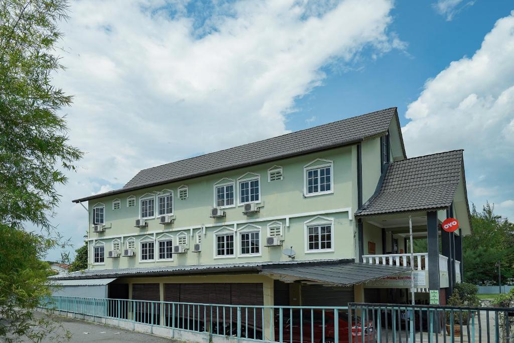 班吉Super OYO 90009 Bangi Sri Minang Guesthouse的绿色房子,设有白色窗户和围栏