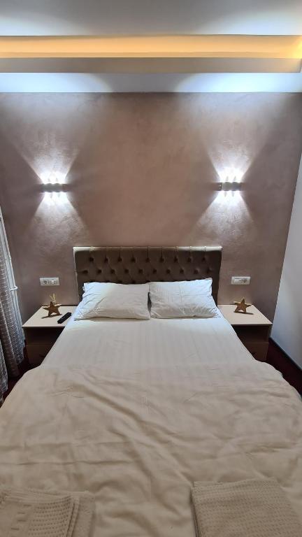 拉姆尼库沃尔恰Studio Albert的一间卧室配有一张带2个床头柜的大型白色床