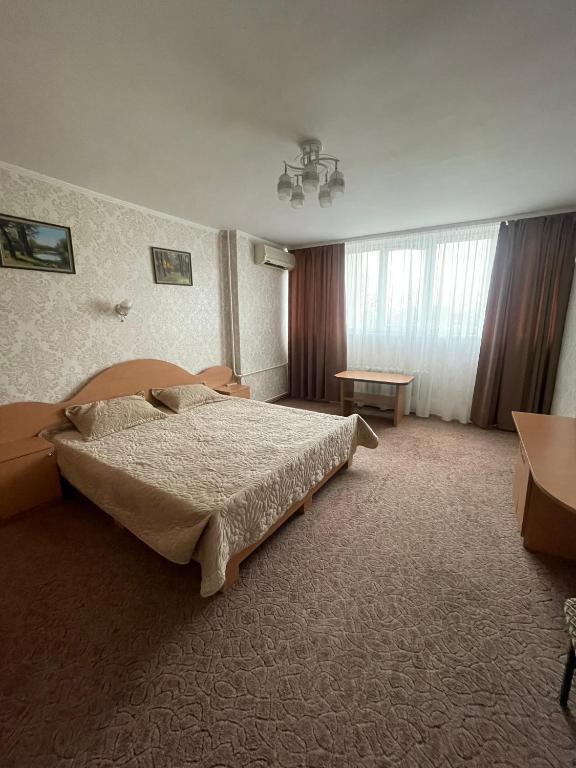 基希讷乌扎雷亚酒店的一间卧室配有一张大床和一张桌子