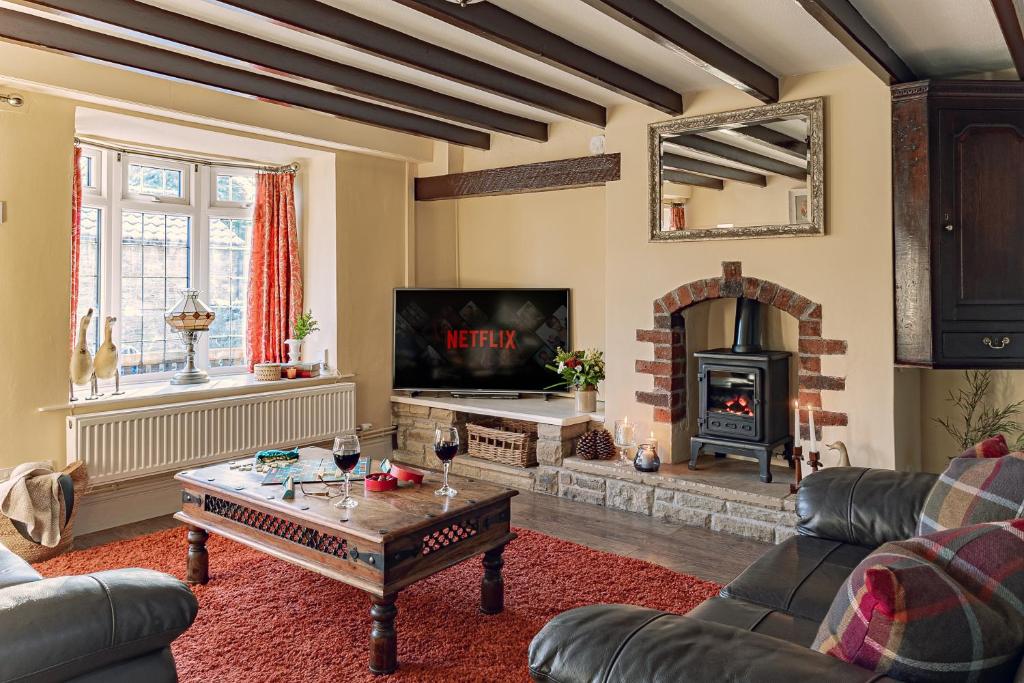斯卡伯勒Garth Cottage in West Ayton的客厅设有壁炉和桌子