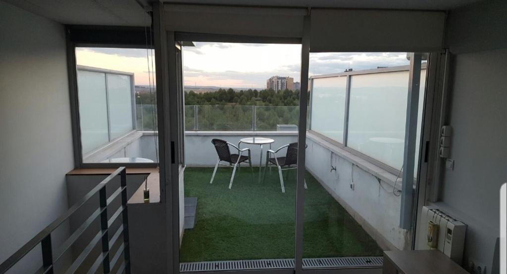 马德里Ático,loft ,duplex的阳台配有桌椅,享有风景。