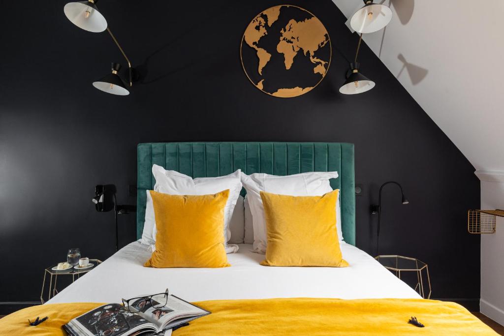 莫索特Hôtel - Restaurant Le Globe的一间卧室配有一张带黄色枕头的大床